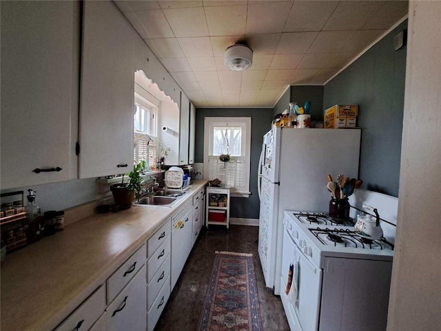 kitchen with white cabinets, white gas stove, and sink