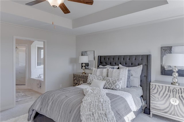 carpeted bedroom with crown molding, ceiling fan, connected bathroom, and a tray ceiling