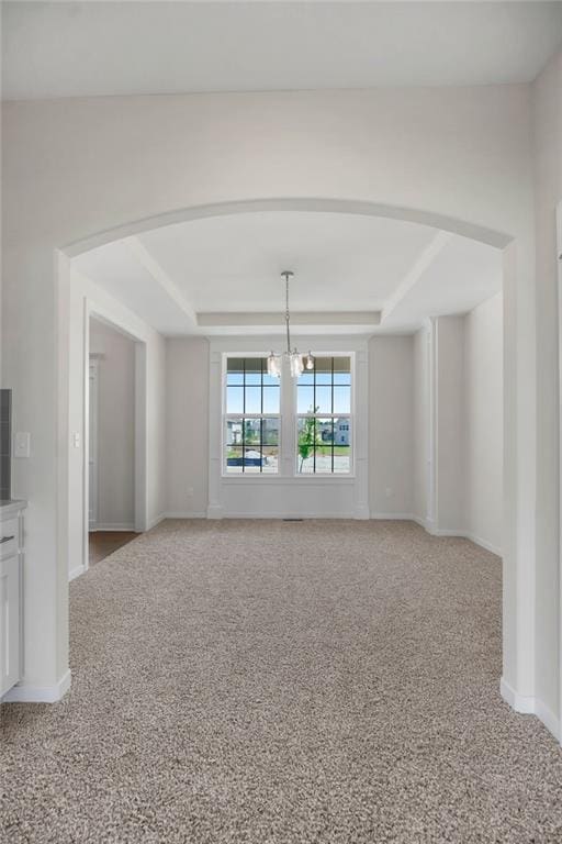 17157 W 164th Ter, Olathe, KS 66062 - unfurnished room featuring a tray ceiling, light carpet, arched walkways, and a chandelier
