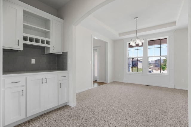 17157 W 164th Ter, Olathe, KS 66062 - kitchen with open shelves, a chandelier, backsplash, arched walkways, and light carpet