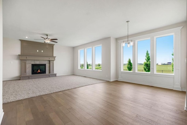 17157 W 164th Ter, Olathe, KS 66062 - unfurnished living room featuring a ceiling fan, wood finished floors, a chandelier, and a large fireplace