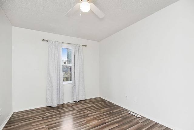 empty room featuring dark hardwood / wood-style flooring, a textured ceiling, and ceiling fan