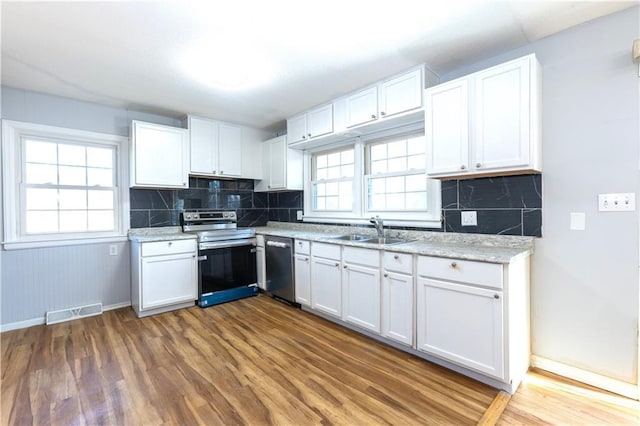 kitchen featuring plenty of natural light, white cabinets, and stainless steel appliances