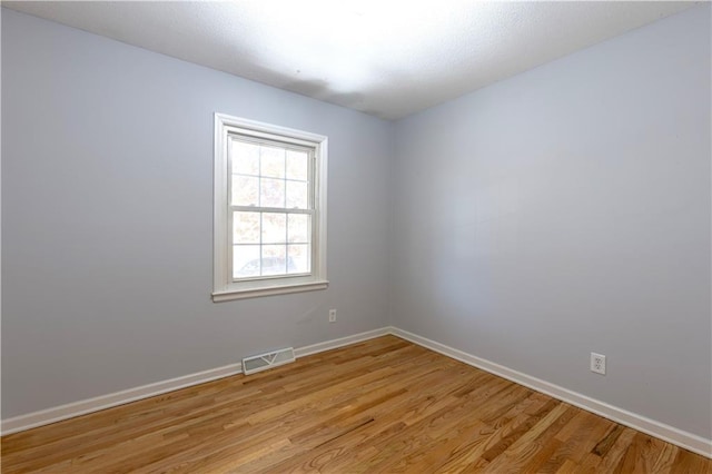 empty room with light hardwood / wood-style flooring