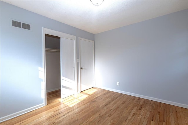 unfurnished bedroom featuring a closet and light wood-type flooring