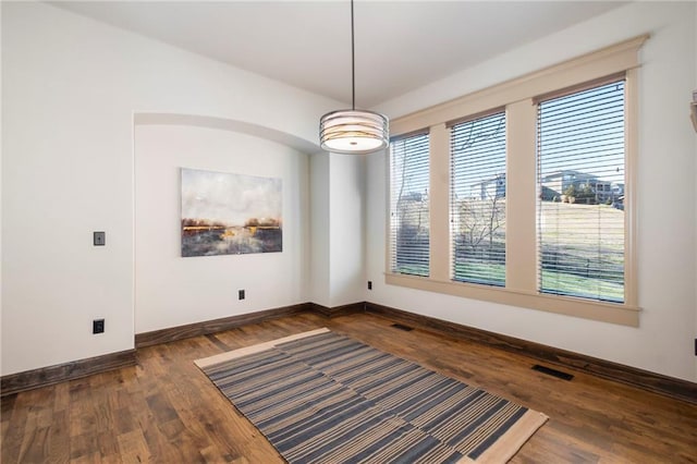 unfurnished dining area featuring dark hardwood / wood-style floors and a wealth of natural light