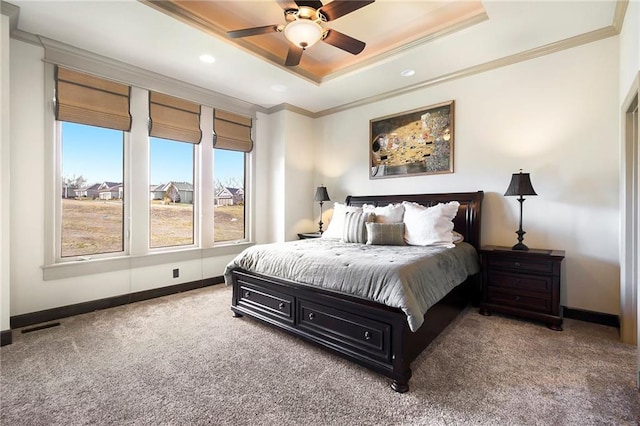 carpeted bedroom with a raised ceiling, crown molding, and ceiling fan