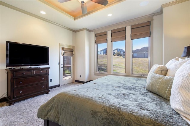 carpeted bedroom with access to exterior, a tray ceiling, ornamental molding, and ceiling fan