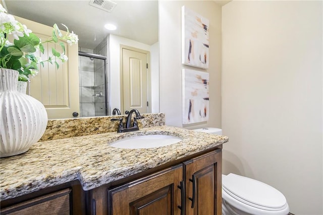 bathroom featuring walk in shower, vanity, and toilet