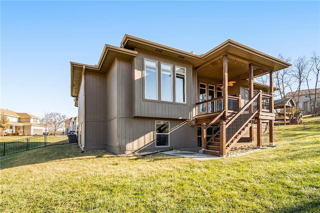 rear view of property with a wooden deck and a lawn