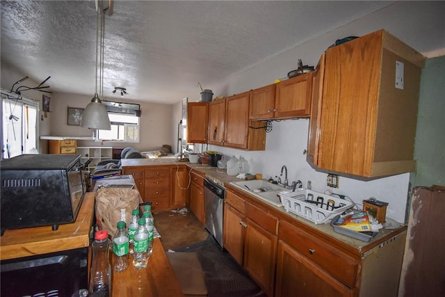 kitchen featuring sink, stainless steel dishwasher, a textured ceiling, decorative light fixtures, and kitchen peninsula