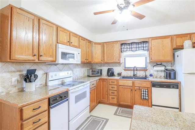 kitchen featuring backsplash, ceiling fan, white appliances, and sink