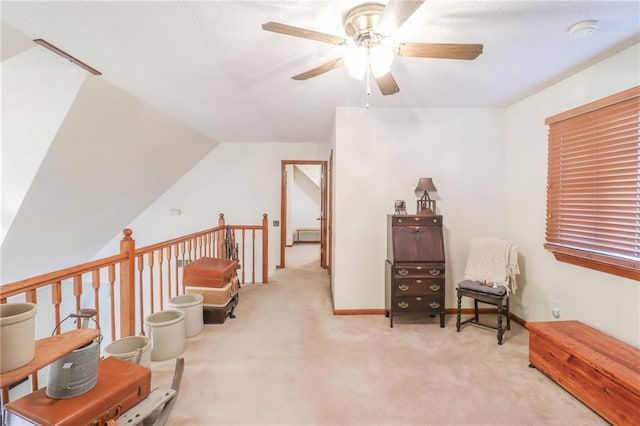 sitting room featuring ceiling fan, light colored carpet, and vaulted ceiling