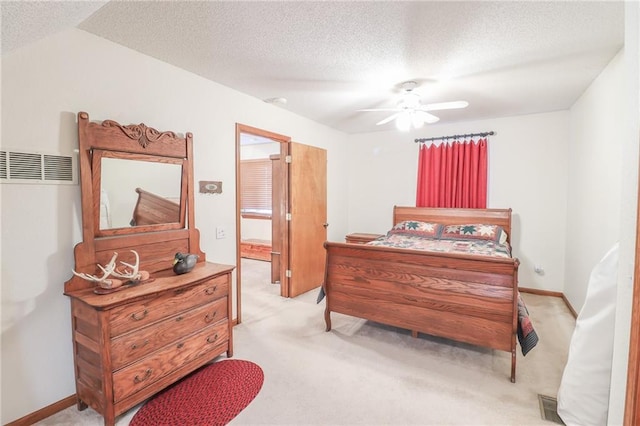 carpeted bedroom featuring ceiling fan and a textured ceiling