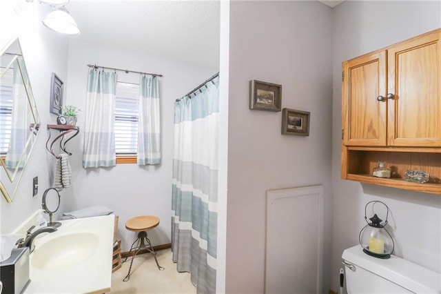 bathroom with toilet, curtained shower, and sink