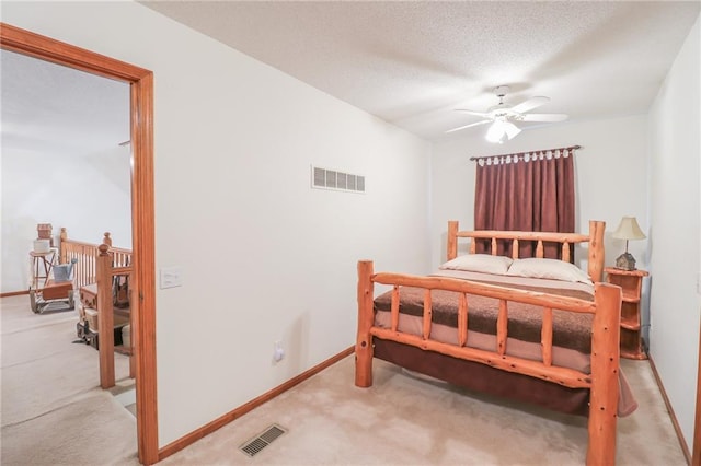 carpeted bedroom with a textured ceiling and ceiling fan