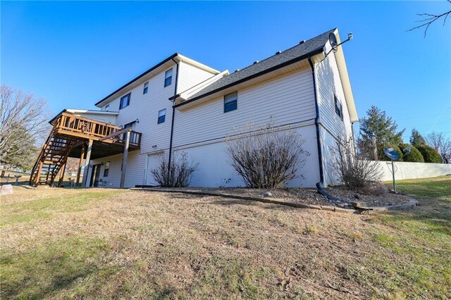 back of property featuring a deck and a yard