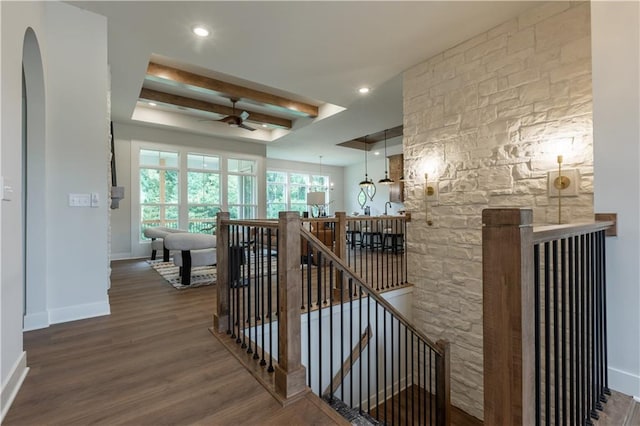 stairs featuring hardwood / wood-style floors, ceiling fan, and beamed ceiling