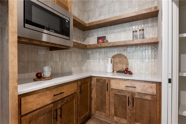 kitchen with tasteful backsplash and stainless steel microwave