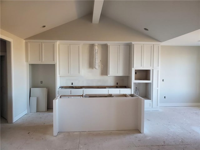 kitchen with a center island, white cabinetry, and lofted ceiling with beams