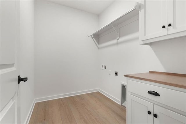 laundry room with cabinet space, baseboards, light wood-style flooring, hookup for a washing machine, and electric dryer hookup