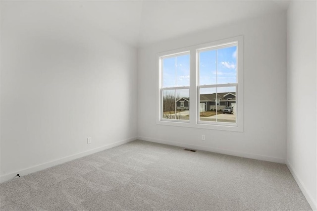 unfurnished room featuring light colored carpet, visible vents, and baseboards