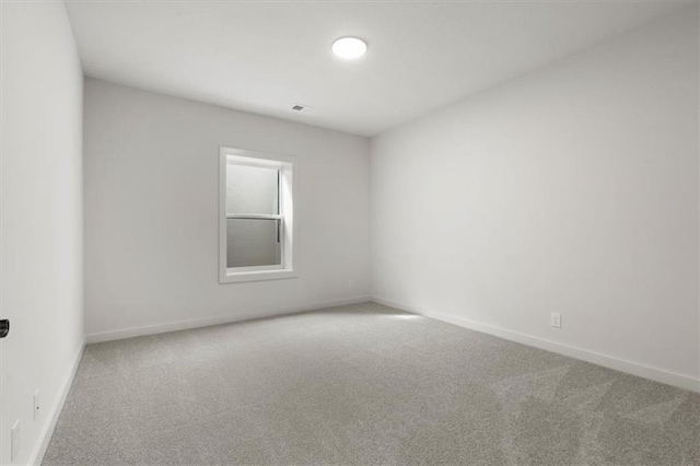 unfurnished room with carpet, visible vents, and baseboards