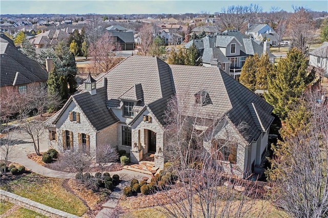 exterior space with a residential view, stone siding, and a tiled roof