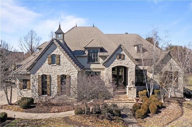 french country style house with stone siding