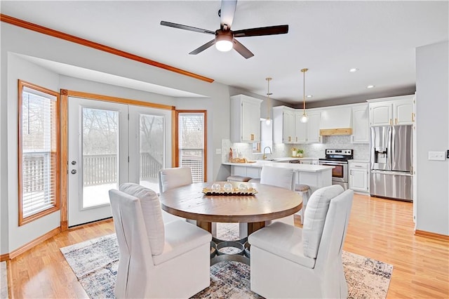 dining area with sink, ceiling fan, a healthy amount of sunlight, and light hardwood / wood-style flooring