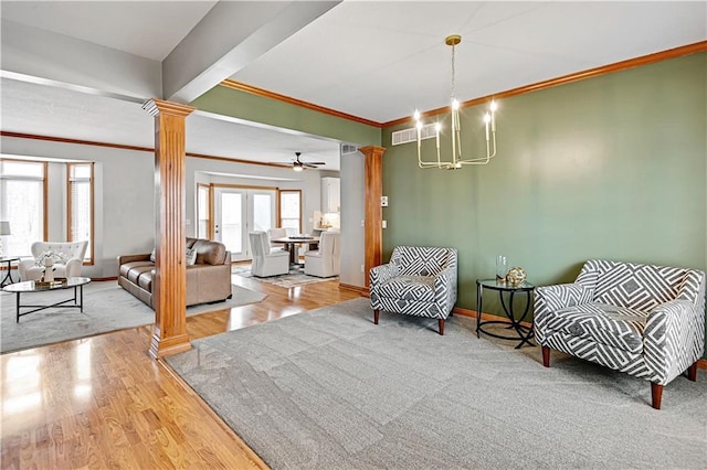 sitting room featuring decorative columns, hardwood / wood-style floors, crown molding, and a healthy amount of sunlight