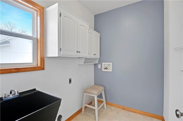 clothes washing area with sink, electric dryer hookup, cabinets, and washer hookup