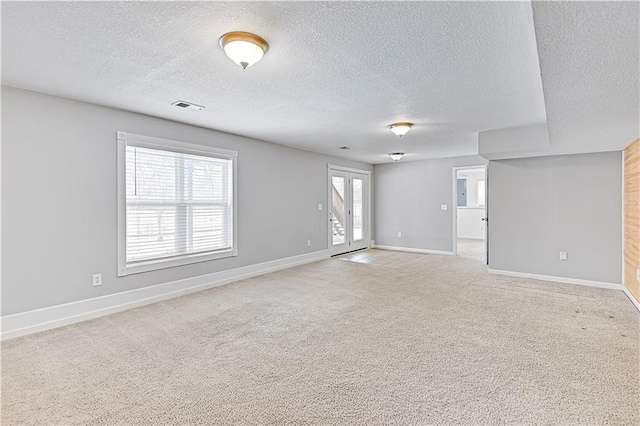 carpeted spare room featuring a textured ceiling