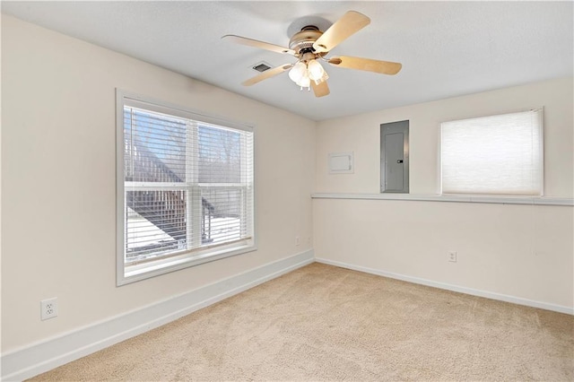 carpeted empty room featuring ceiling fan and electric panel