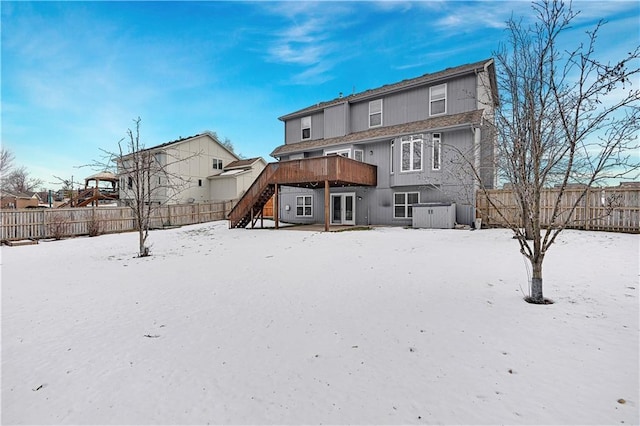 snow covered back of property featuring a deck