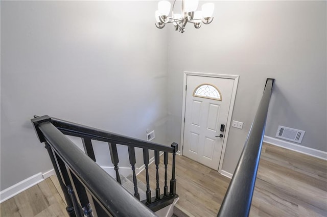 foyer entrance featuring light wood-type flooring and an inviting chandelier