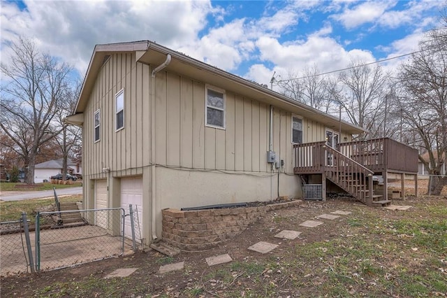 view of home's exterior featuring a garage and a deck