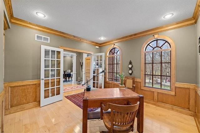 dining area featuring crown molding, french doors, and light hardwood / wood-style flooring