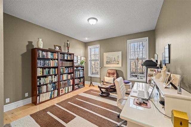 office area featuring light hardwood / wood-style flooring and a textured ceiling