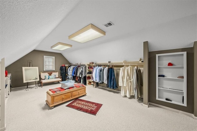 walk in closet with lofted ceiling and carpet floors