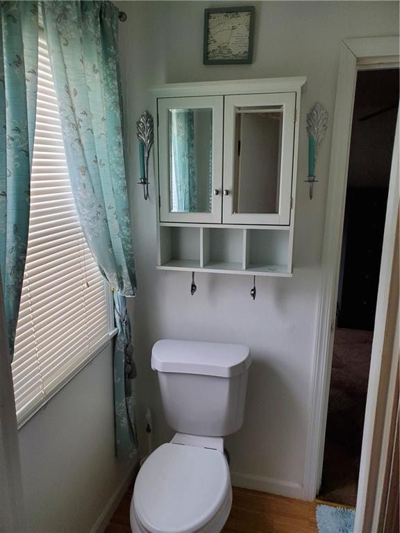 bathroom with toilet and hardwood / wood-style floors