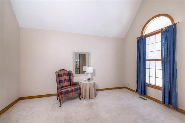 living area featuring vaulted ceiling and carpet floors