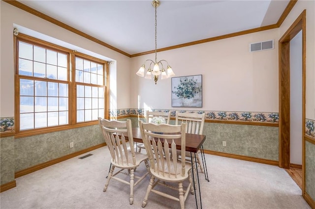 carpeted dining room featuring an inviting chandelier and crown molding