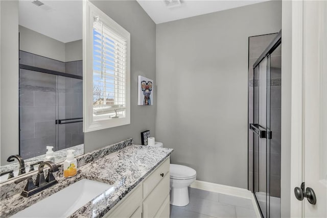 bathroom with tile patterned flooring, vanity, toilet, and walk in shower