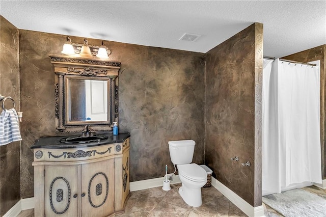 bathroom with a textured ceiling, vanity, toilet, and curtained shower