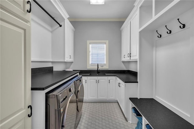 kitchen with white cabinetry, washer and clothes dryer, sink, and ornamental molding