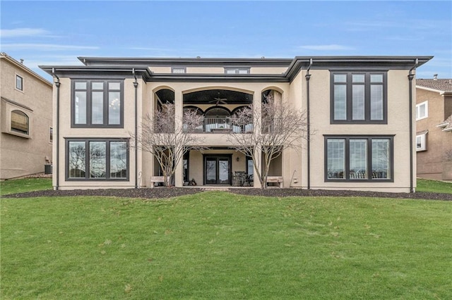 back of property with a balcony and a yard