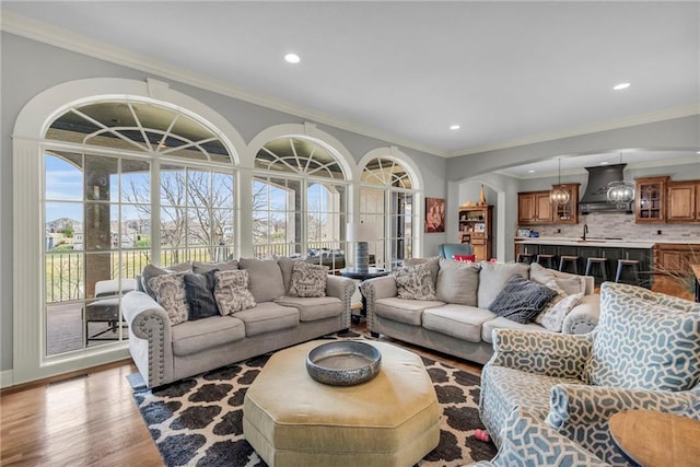 living room featuring light wood-type flooring and crown molding