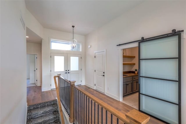 entrance foyer with a notable chandelier, light wood-type flooring, and french doors