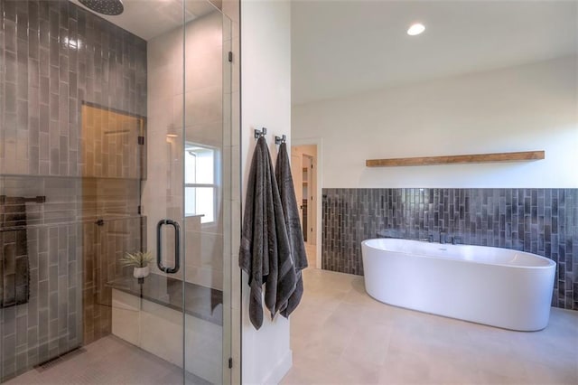 bathroom featuring tile patterned floors, shower with separate bathtub, and tile walls